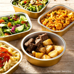 Various shapes of premium gold aluminum foil food containers from Foiltrust, featuring a heavy-duty, 100% recyclable design holding assorted hot and cold meals.